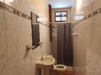 Bathroom with white tiled walls pedestal sink shower Equus Village Pedasí Panama