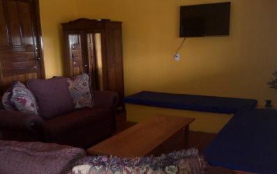 Spacious living area with sofa, TV and wooden furniture in Pedasí Panama