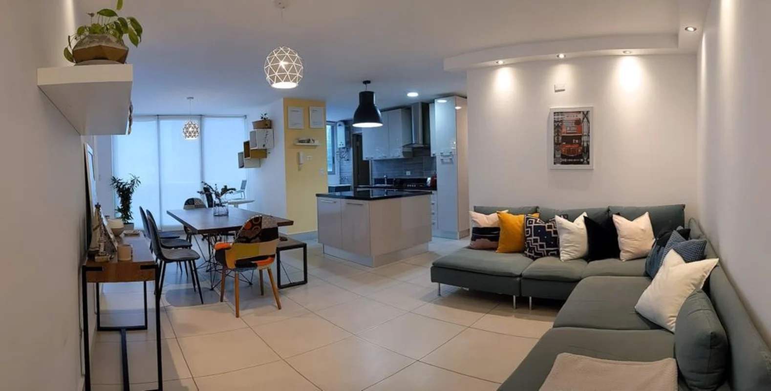 Spacious open plan living, dining, and kitchen area with large windows in PH Park City apartment for rent in Obarrio Panama