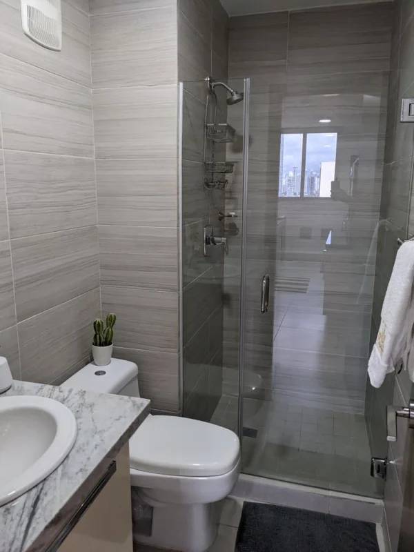 Modern bathroom with marble vanity and glass shower at PH Park City apartment rental Panama City