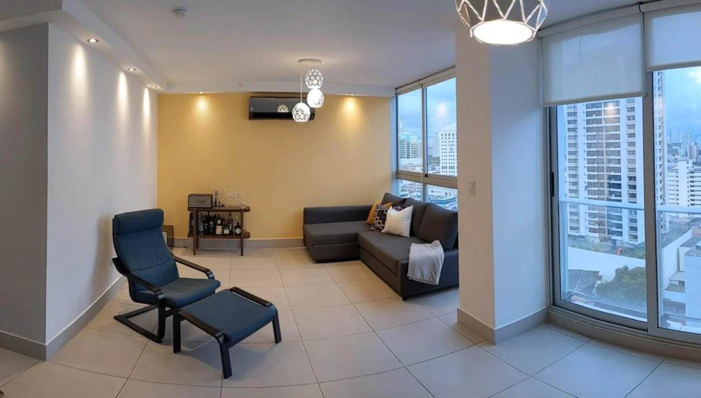Bright living room with large windows overlooking Panama city skyline in PH Park City Obarrio apartment