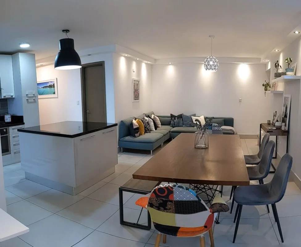 Open-plan living, dining and kitchen with island in PH Park City apartment for rent Panama City