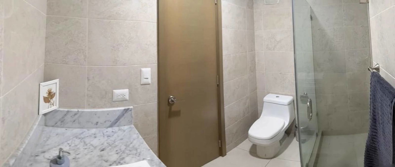 Modern bathroom with glass shower and marble counter in PH Park City rental apartment Obarrio Panama