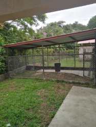 Covered kennel pet enclosure in fenced yard of Villas de Howard house Panama city outskirts