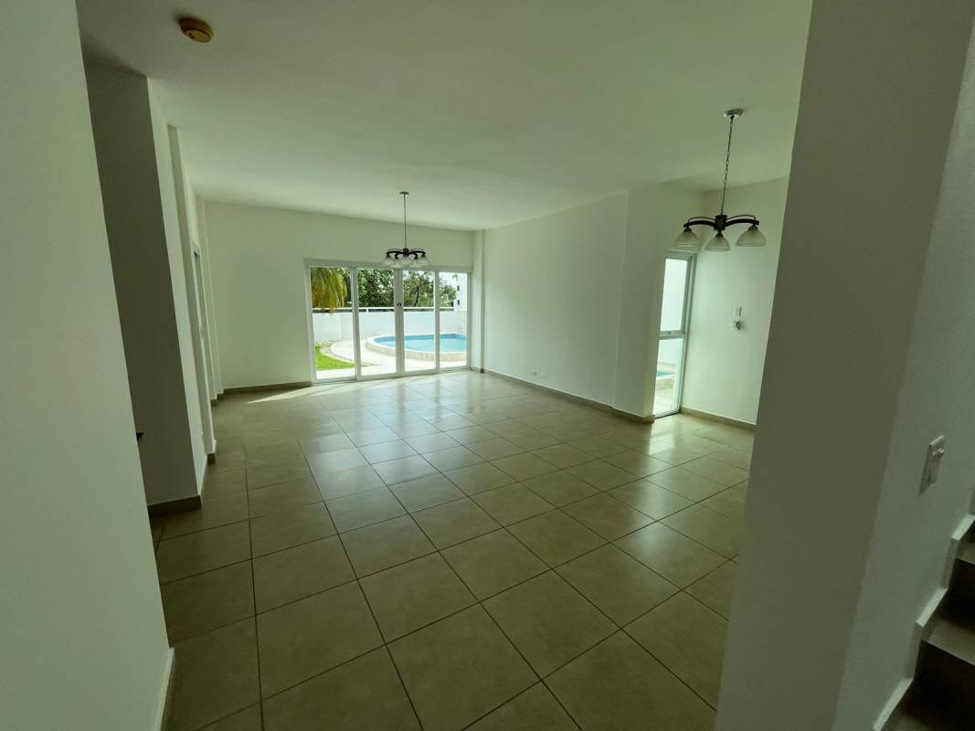 Living room with large glass doors opening to swimming pool luxury home Condado del Rey Panama