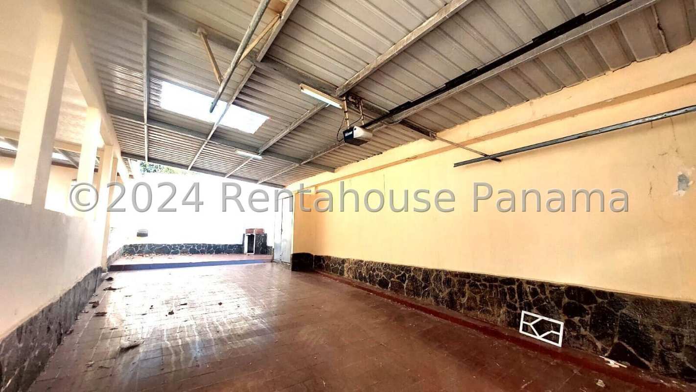 Covered garage with metal roof, tiled floor, stone wall details Villa Zaita Panama