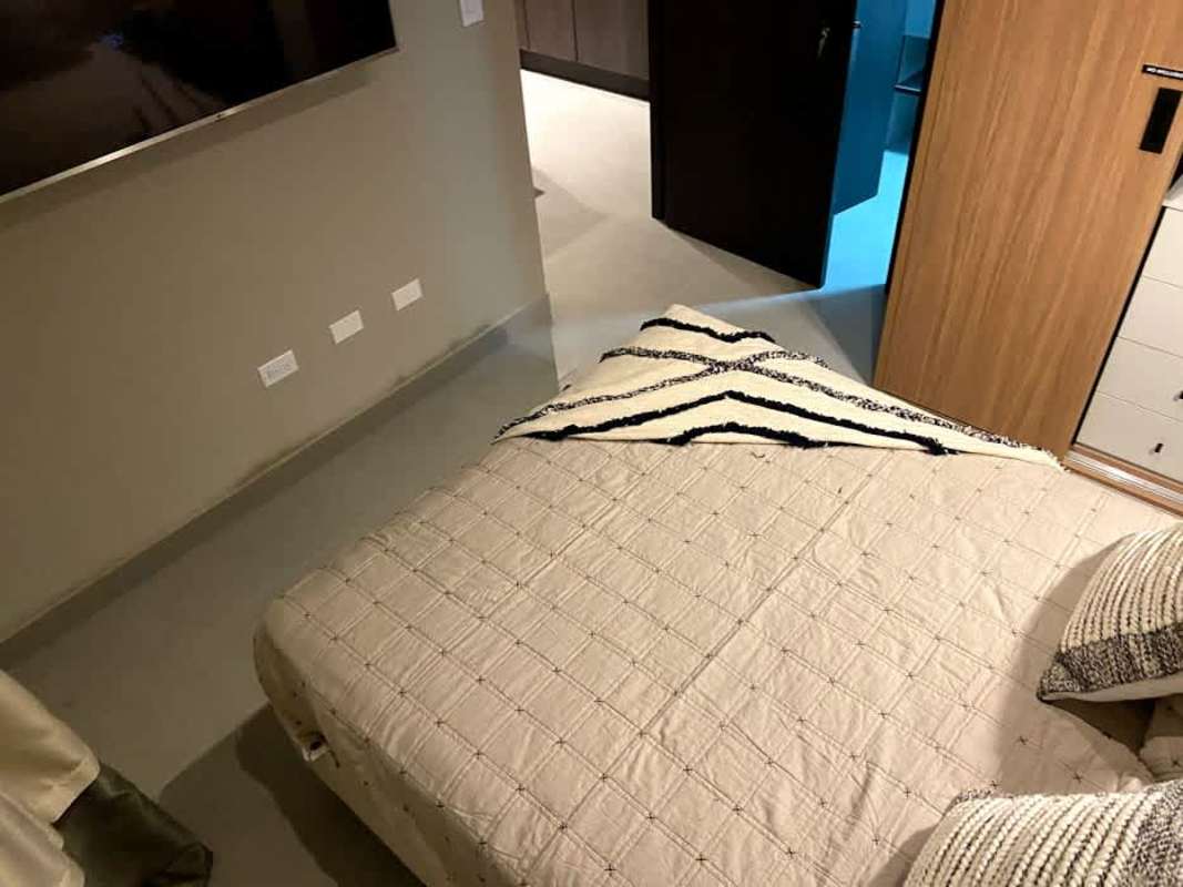 Bedroom with city skyline views through large window at PH Obarrio Edge Residence Panama