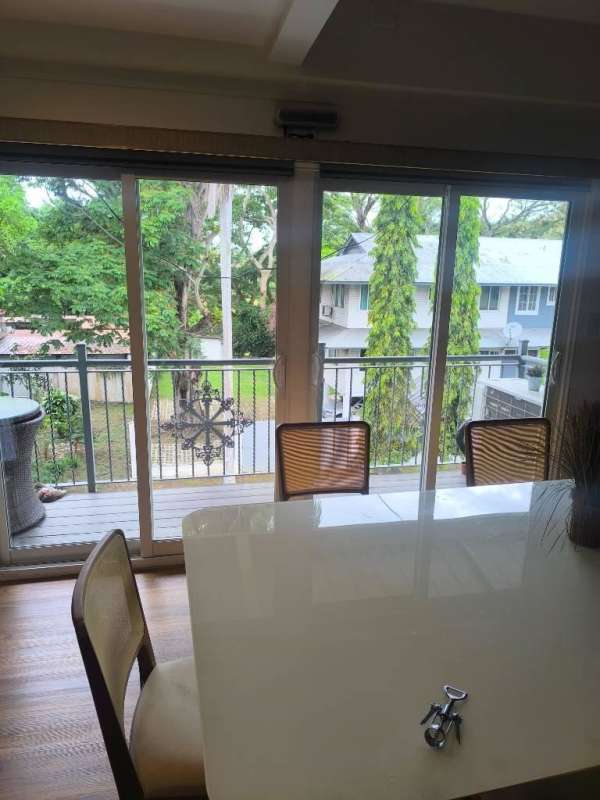 Dining room with sliding glass doors to balcony overlooking greenery at Amador Residences Panama City
