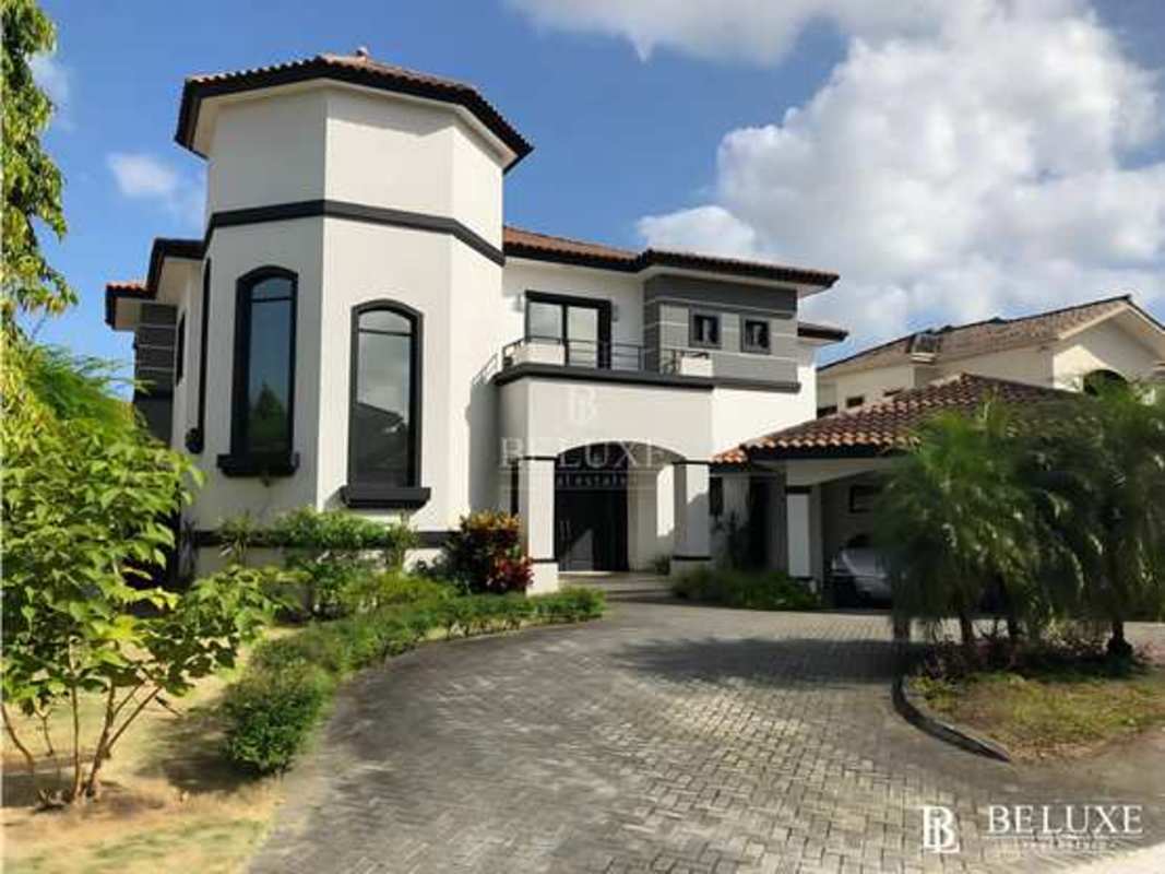 Dining room with modern chandelier and large windows at Costa del Este villa Panama