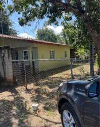 Yellow one story house fenced yard tiled roof trees parked car Guararé Los Santos Panama