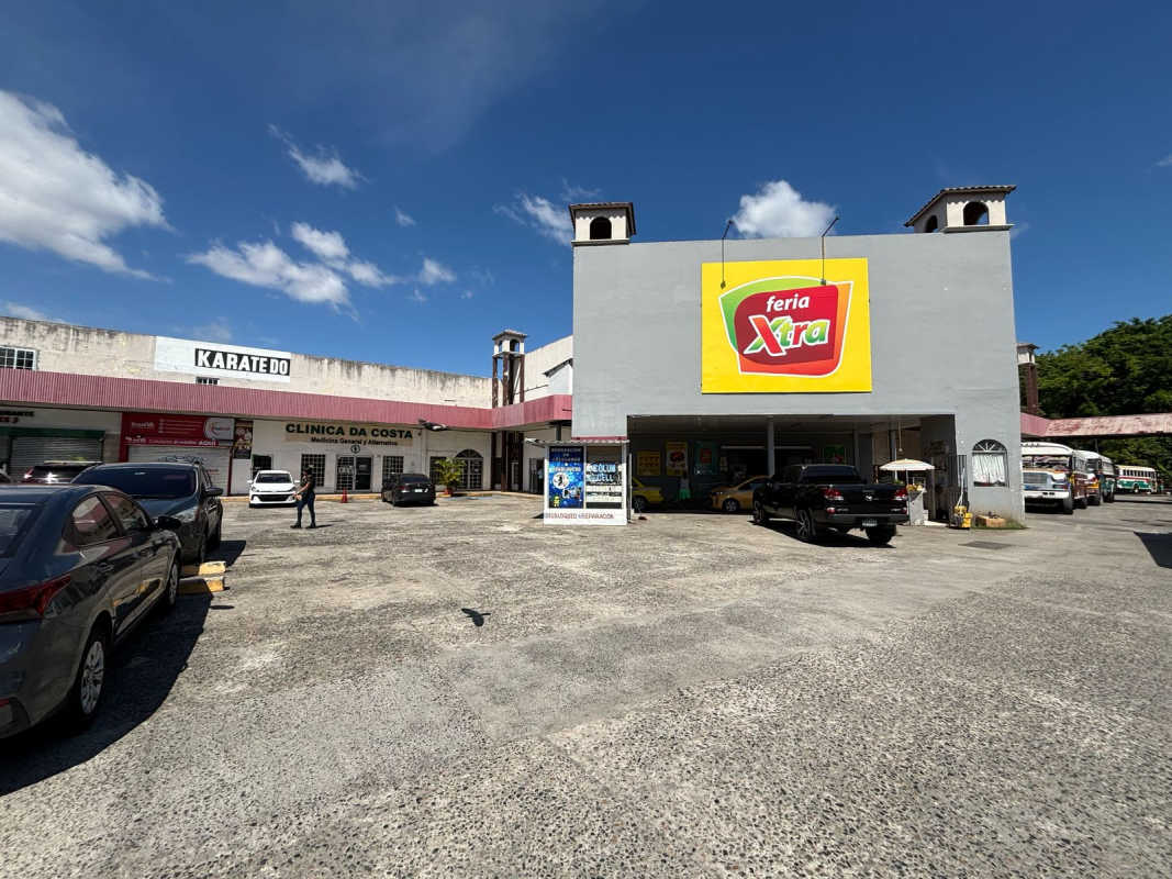 Commercial retail complex exterior with various storefronts and parking spaces in Panama City Las Mañanitas