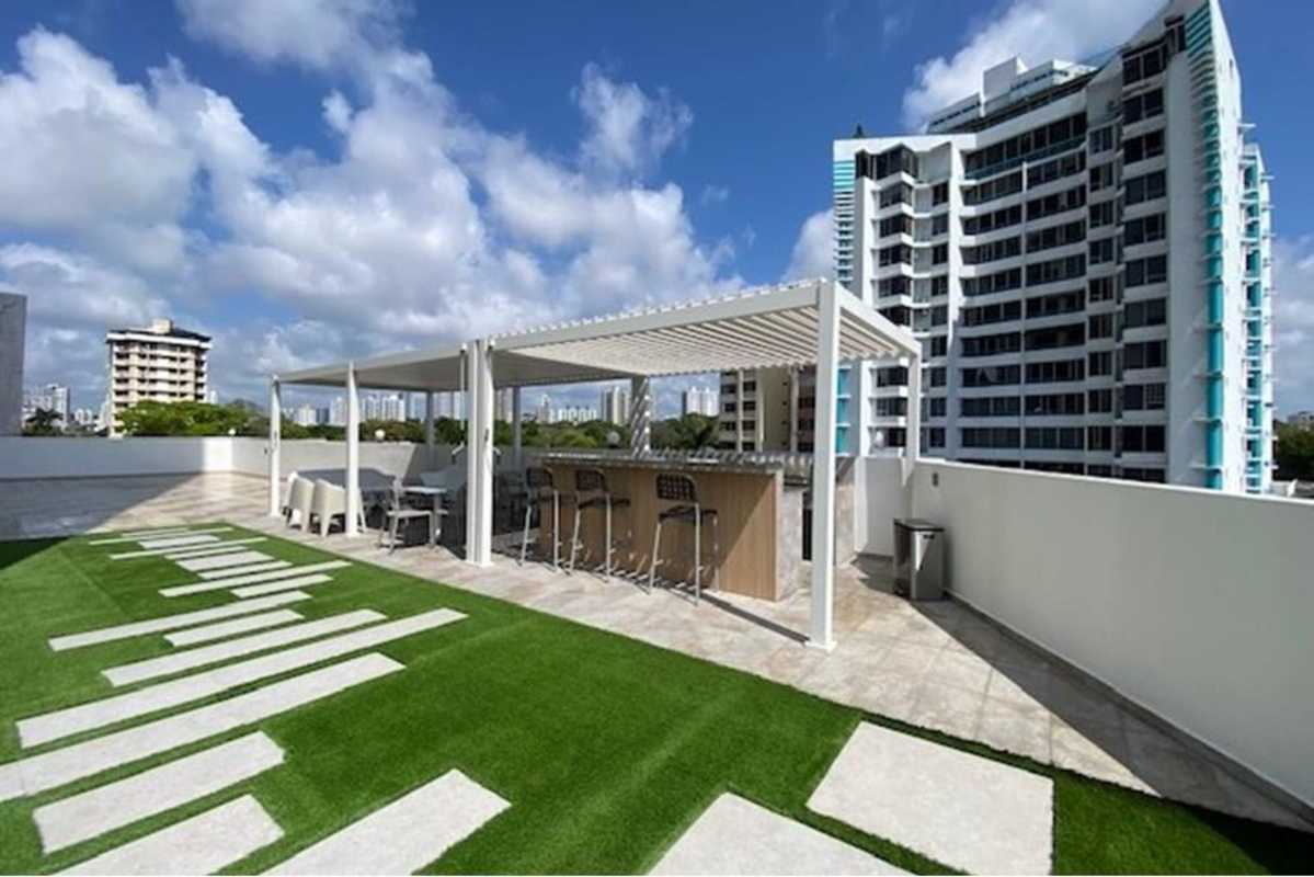 Modern semi-open kitchen with granite counters wood cabinets at PH Sky Blue Tower San Francisco Panama