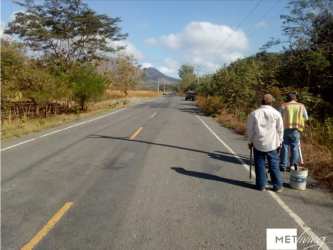 Gravel path with parked vehicle beside rural farmland in Coclé Panama for sale
