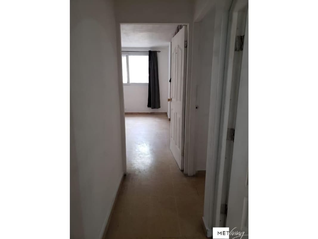Long hallway with white walls, tiled floors, window and doors in Villa Lucre house Panama City