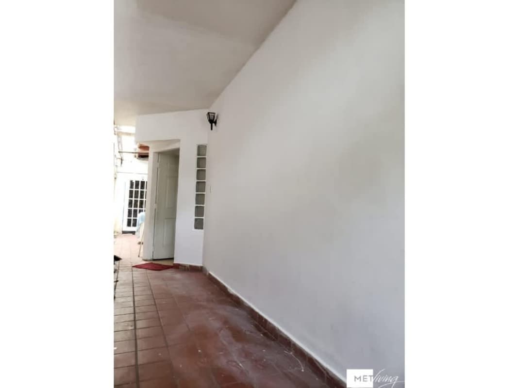 Entrance hallway with glass blocks, white doors, red tile in Villa Lucre house Panama City