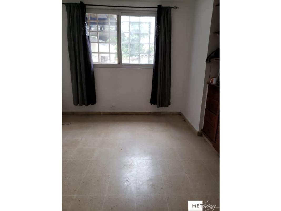 Bedroom with tiled floor, large window dark curtains built-in shelves Villa Lucre Panama City