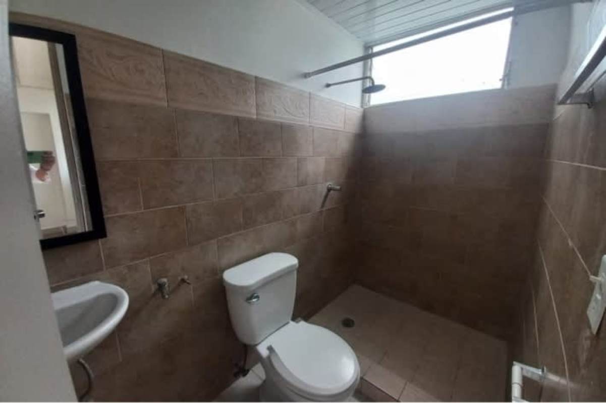 Simple bathroom with brown tiles, walk-in shower, window Calidonia Panama rental