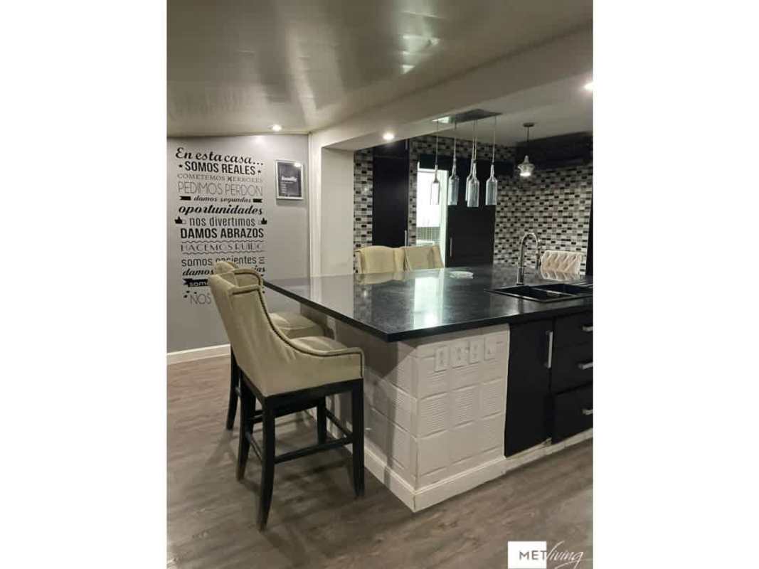 Modern kitchen featuring large island dark cabinetry and pendant lights Crystal Springs Panama City