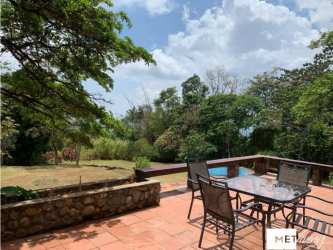 Rustic stone patio metal dining furniture lush trees and swimming pool Cerro Azul Panama
