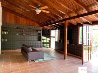 Living room with wood vaulted ceiling, wooden walls, large windows and garden views Cerro Azul Panama