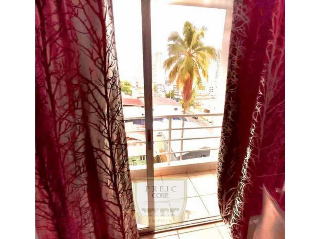 Balcony with sliding glass door overlooking neighborhood and palm trees Panama City