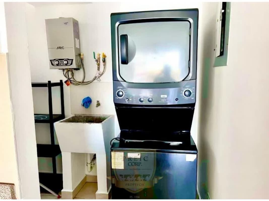 Laundry room with stacked washer dryer, utility sink and shelves Central Park apartments Panama