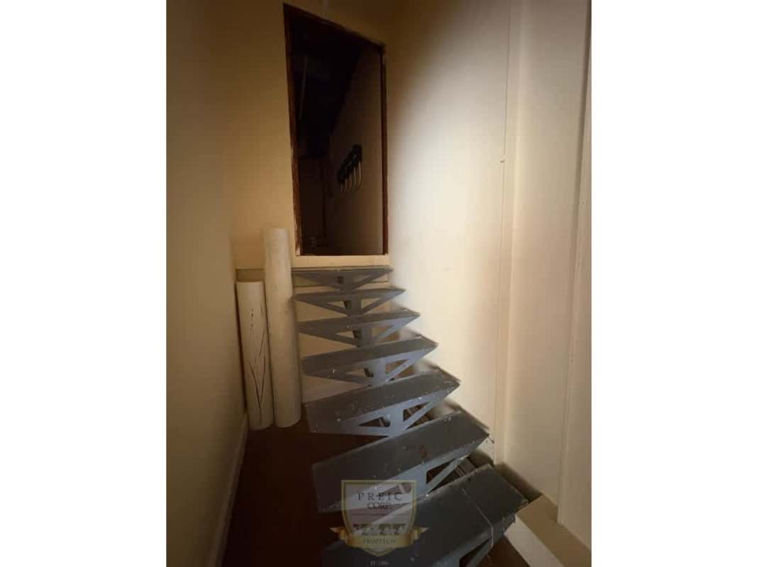 Compact bathroom with lavender walls and utility basin in retail plaza Panama