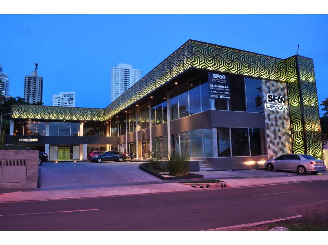 Illuminated exterior of Plaza San Francisco with patterned facade and parking lot at night, Panama City