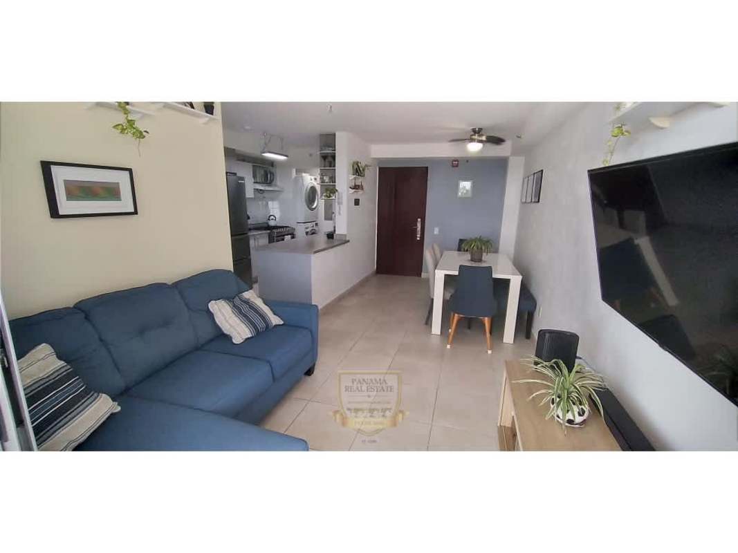 Dining area with blue sofa, ceiling fan, minimalist decor in PH Alegría Panama