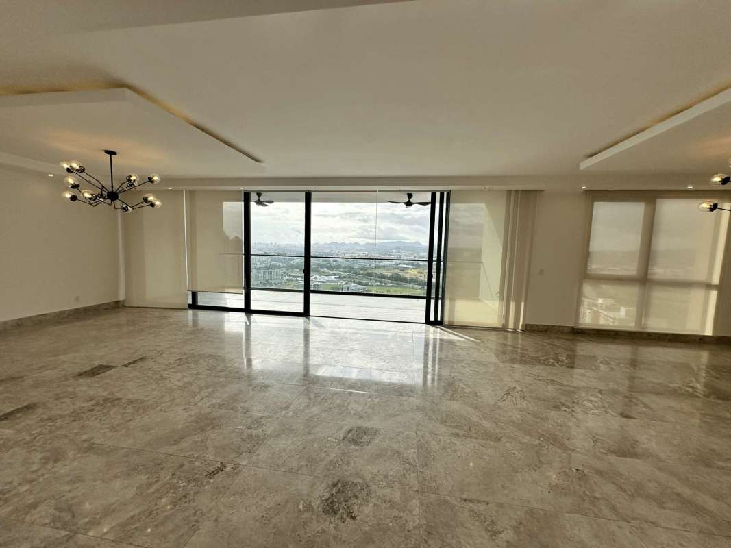 Open living room with marble floors, recessed lighting, city and golf views in Empire Residences Panama
