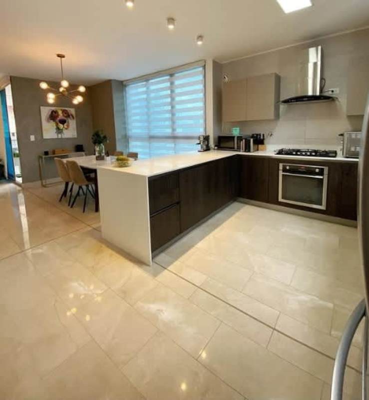 Modern white kitchen with island and dining area PH Vita Coco del Mar Panama City