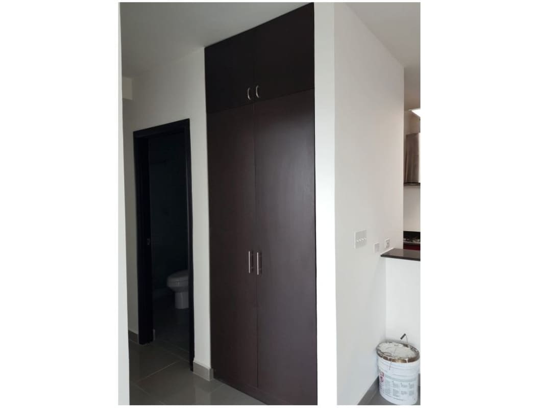 Modern kitchen with red cabinetry, open living area PH Quartier 74 in Panama City