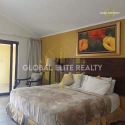 Large bedroom furnished with king bed, floral art, terrace access at PH Las Palmas Panama