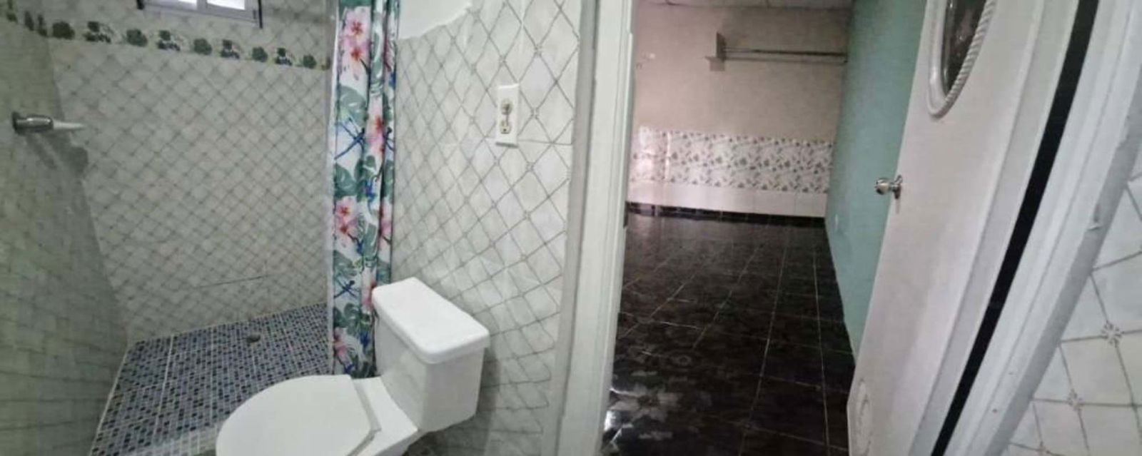 Traditional bathroom with pedestal sink, toilet and tiled walls in affordable rental room Tocumen Panama