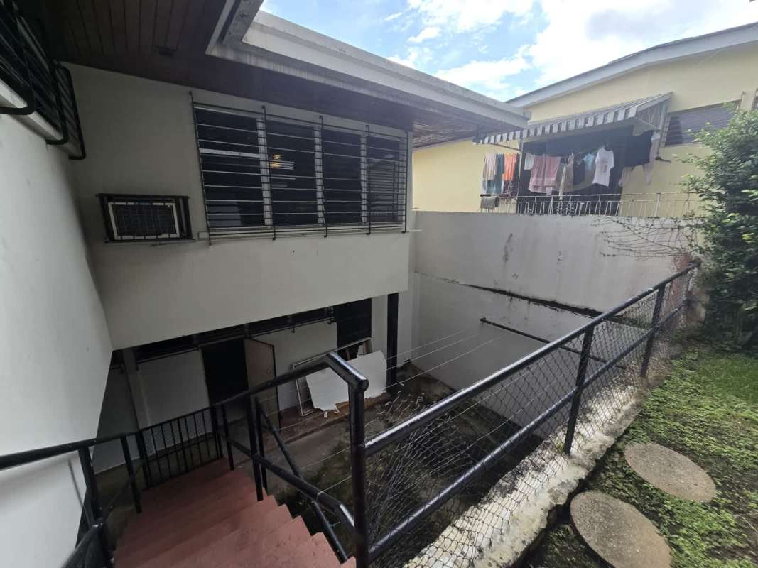 Covered outdoor terrace with wooden ceiling, garden and pool view in Bella Vista Panama City home for sale