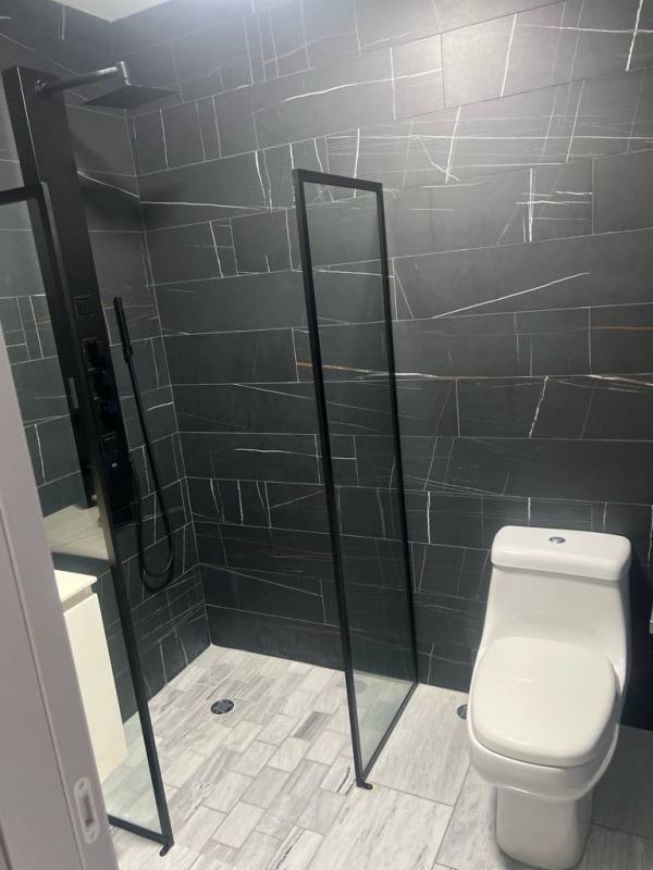 Spacious bathroom with glass shower enclosure and marble finishes in Nuovo by Armani Casa Panama