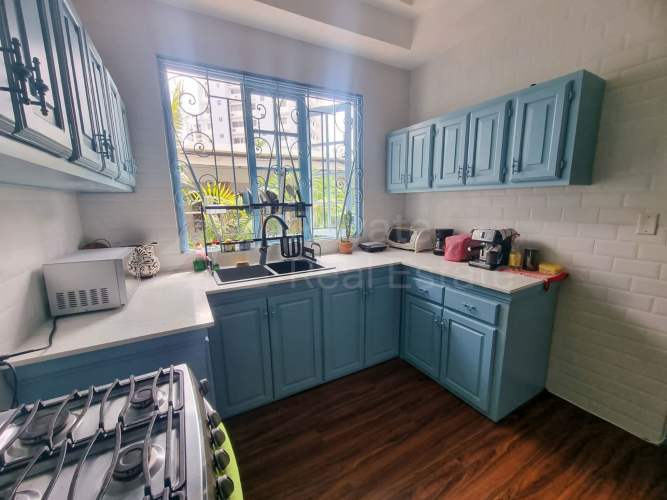 Spacious living room with wood floors and ceiling fans in duplex house Obarrio Panama