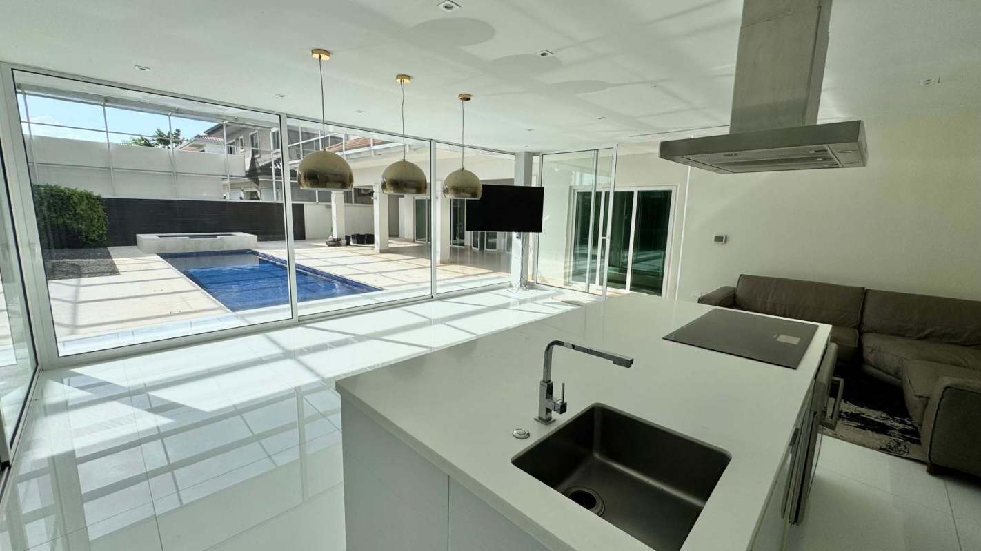 Modern kitchen and living room with large windows overlooking pool in Toscana Costa del Este Panama