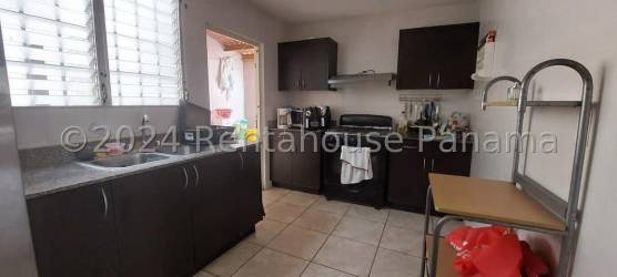 Contemporary kitchen with granite counters and tiled walls in family house Brisas del Golf Panama