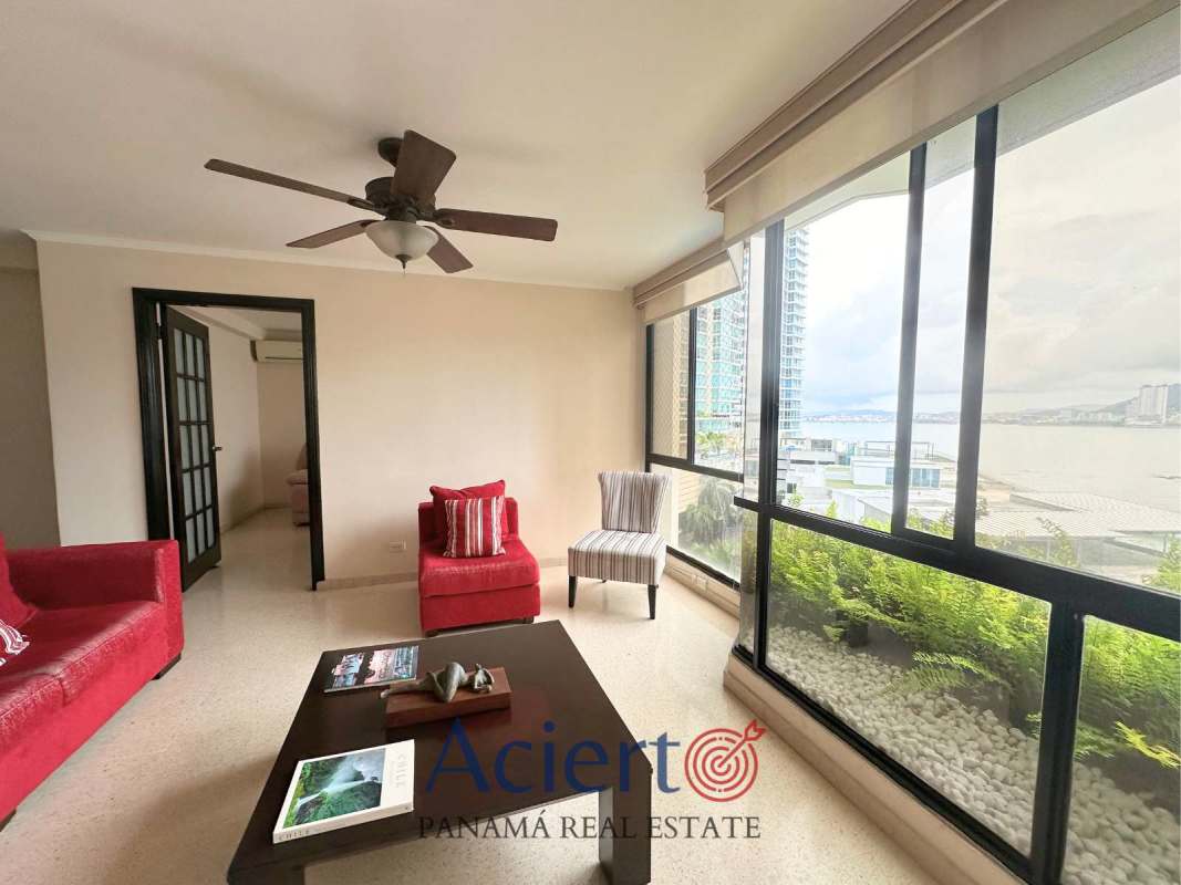 Spacious living and dining area with floor-to-ceiling windows, ocean and city views in PH Punta Paitilla.