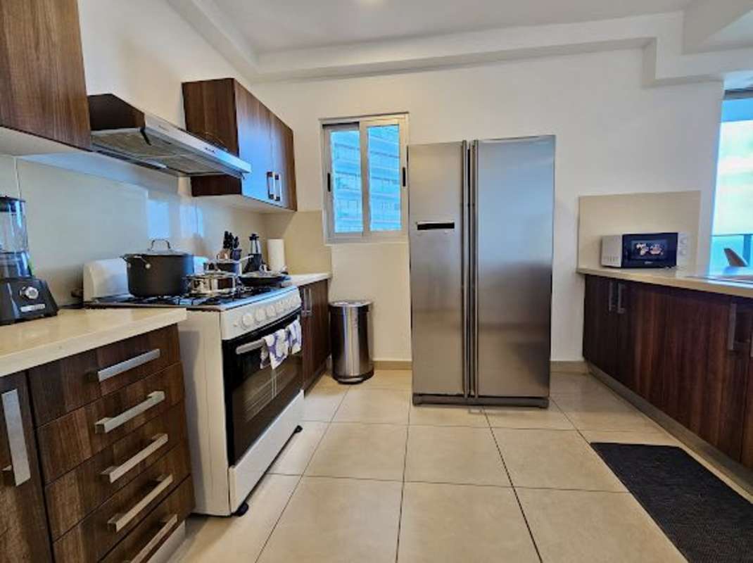 Modern kitchen with quality appliances, granite counters, wood cabinetry in PH Pacific Point Panama