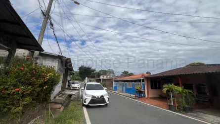 Covered front porch with stone columns, metal gate, driveway and carport in Panama Oeste single family home