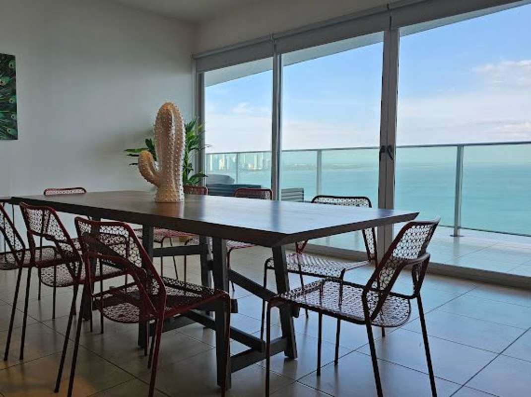 Modern dining room with large windows, balcony access and ocean views at PH Ocean Club Punta Pacifica Panama