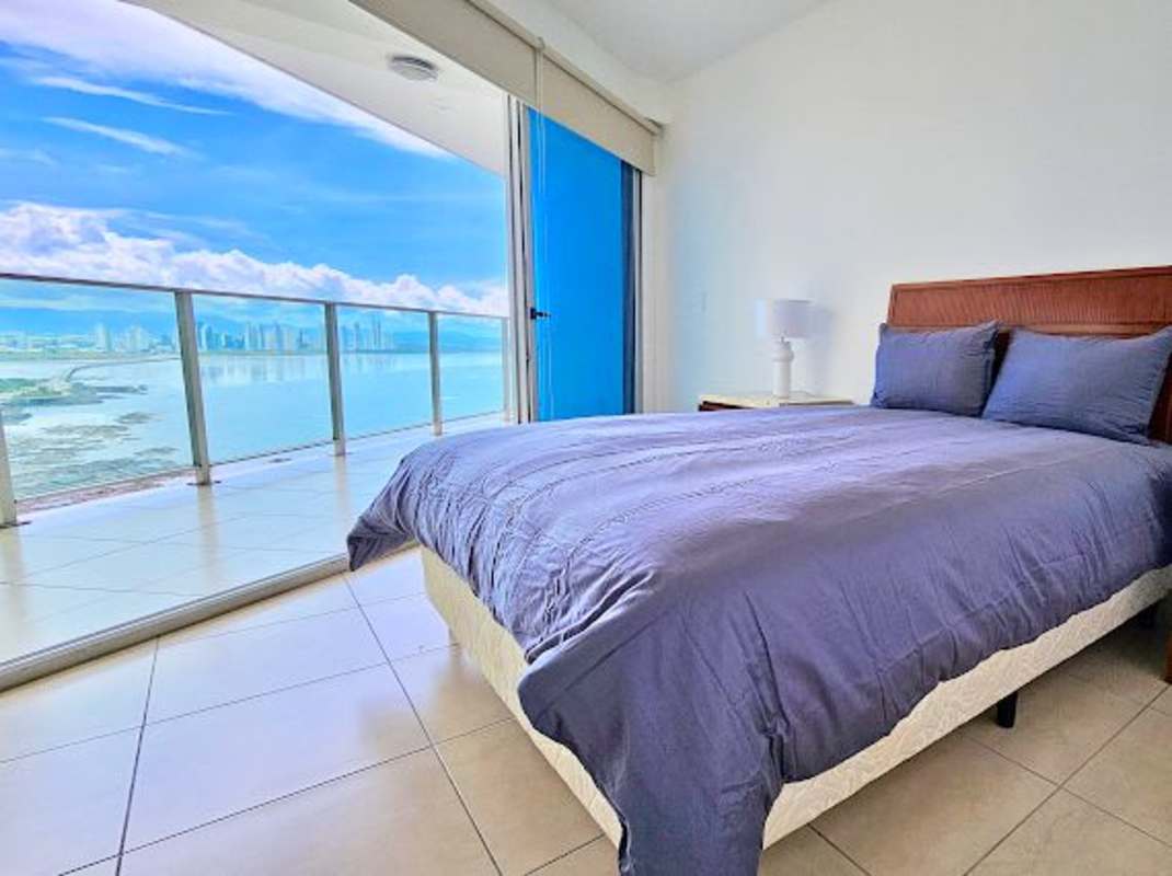 Bright oceanfront bedroom with balcony access at PH Ocean Club, furnished and modern design