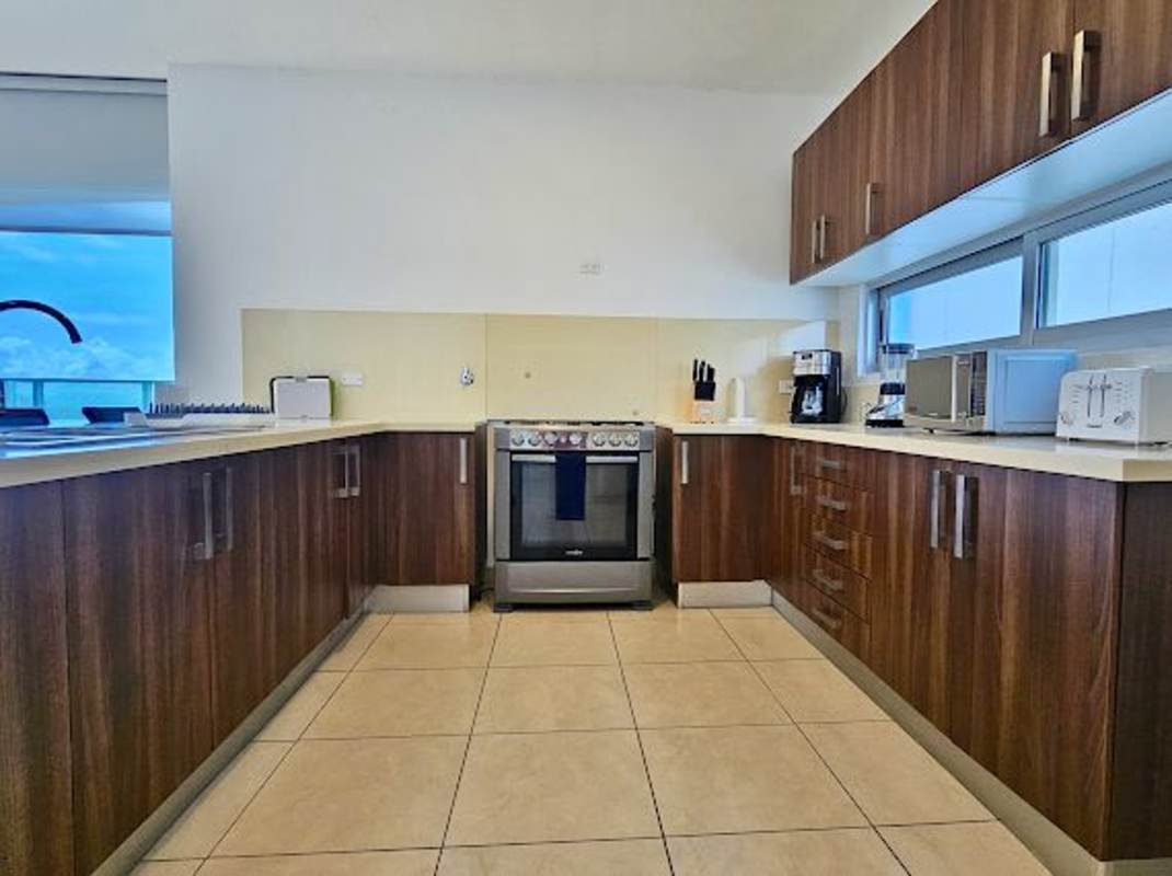 Modern kitchen with U-shaped counter, window, top appliances at Punta Pacifica Ocean Club