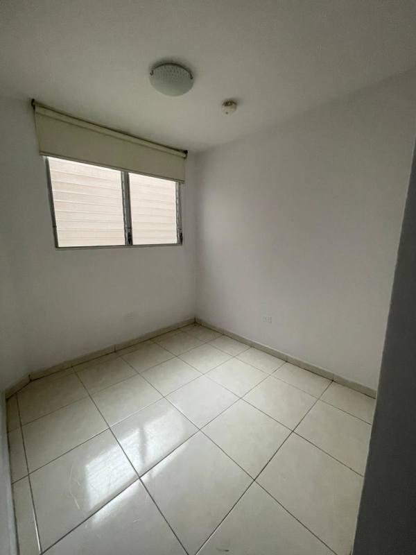 Small bedroom with tiled floor, windows and ceiling light fixture Panama City rental apartment