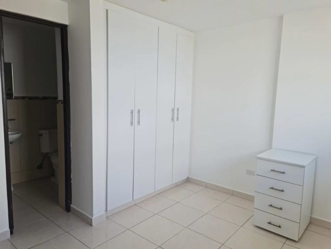 Bedroom with white built-in closet and ceramic tile floor Llano Bonito apartment Panama