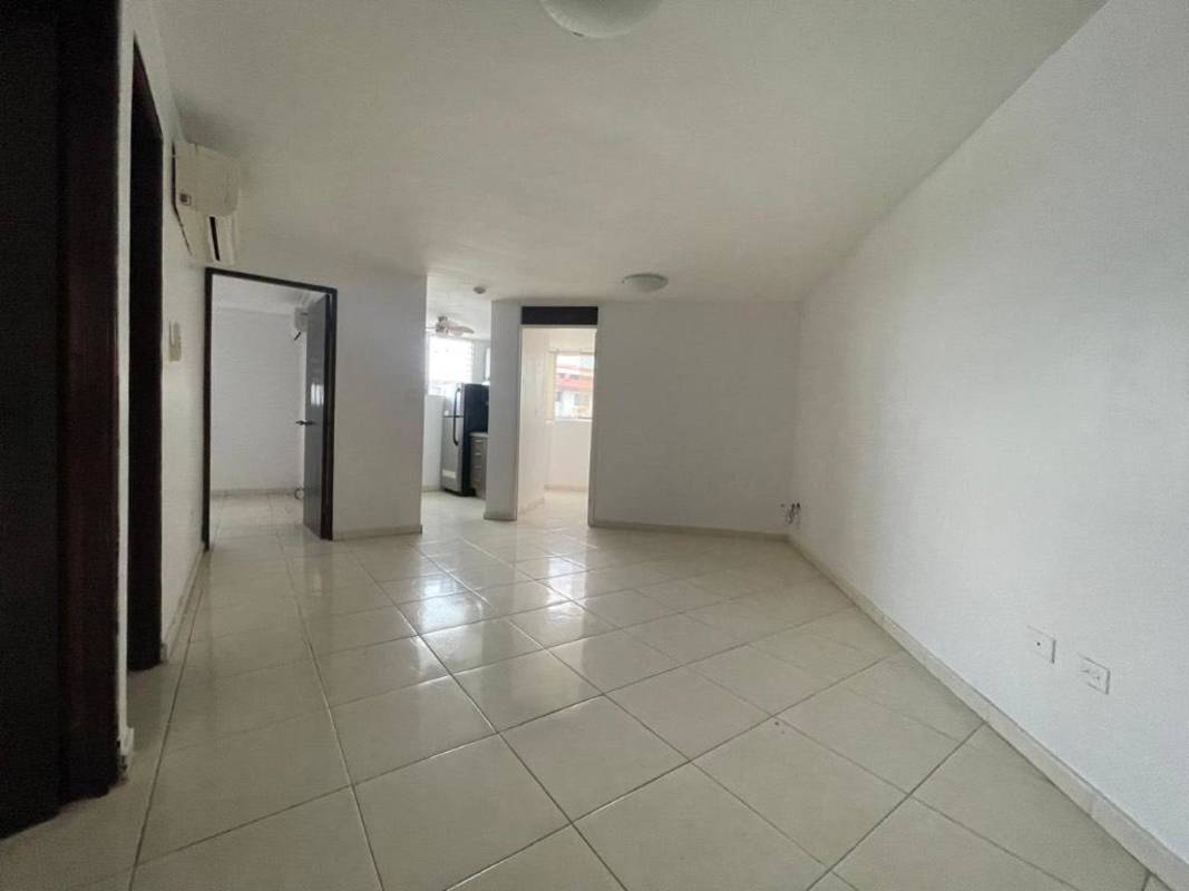 Open living and dining space with white tile floors and split AC unit in Panama apartment Llano Bonito