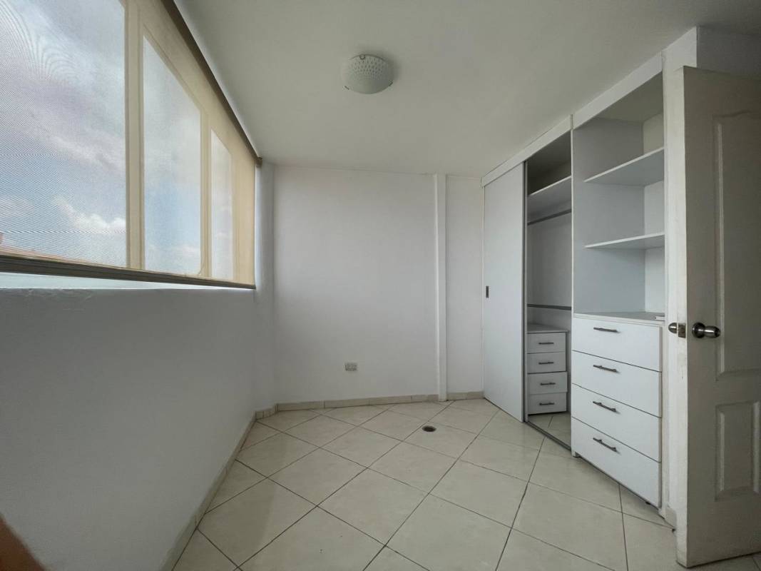 Empty bedroom with large windows built-in white closet and tiled floors Panama City apartment rental