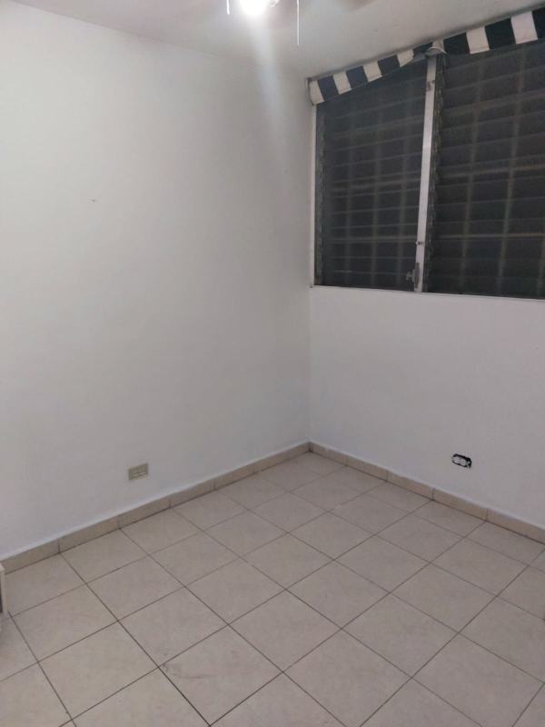Minimalist kitchen with white cabinets and tiled backsplash in Campo Limberg Panama City apartment
